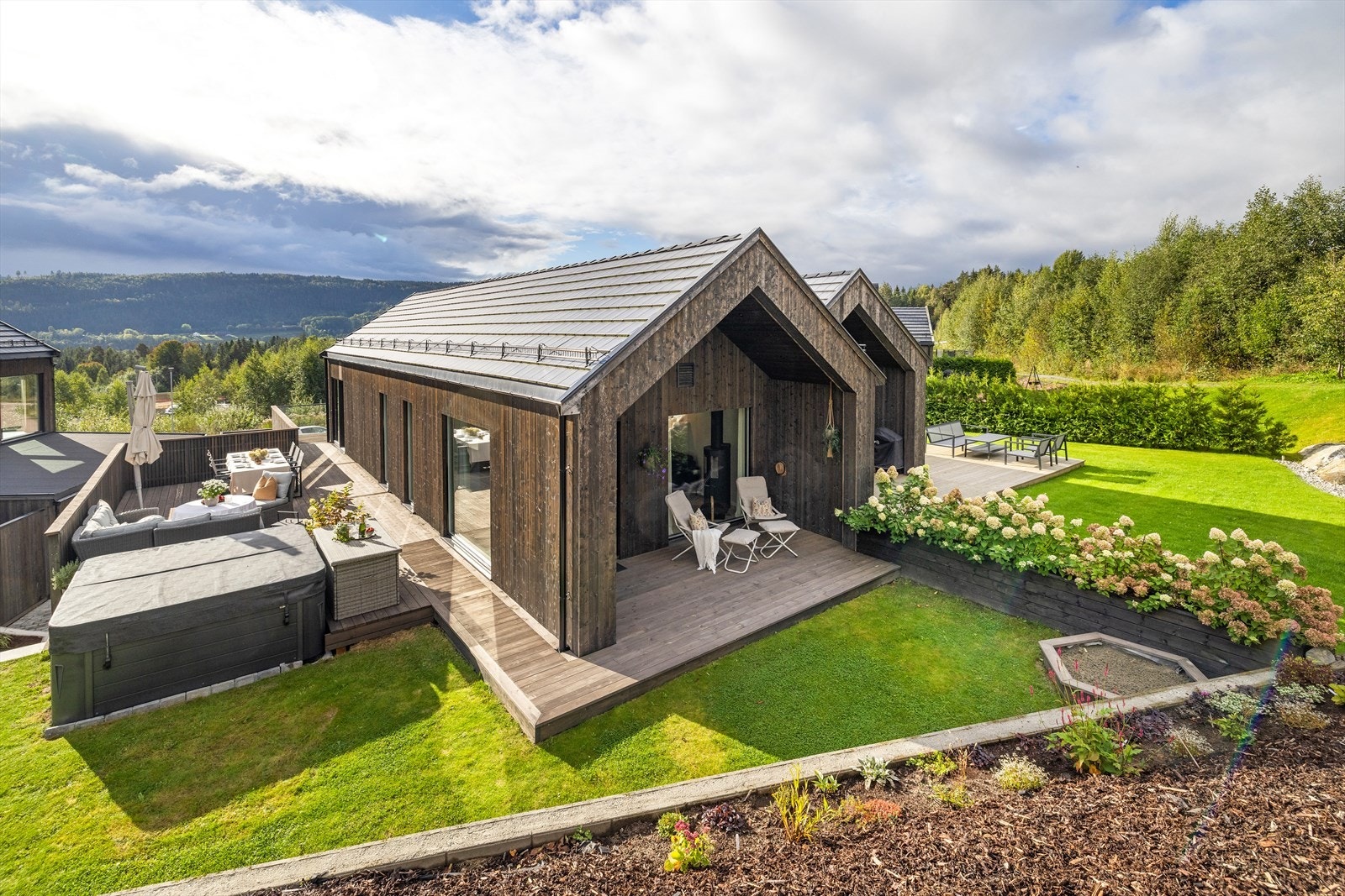 Tomten er opparbeidet med steinlagt innkjørsel, terrasse og gressplen. Galleribilde