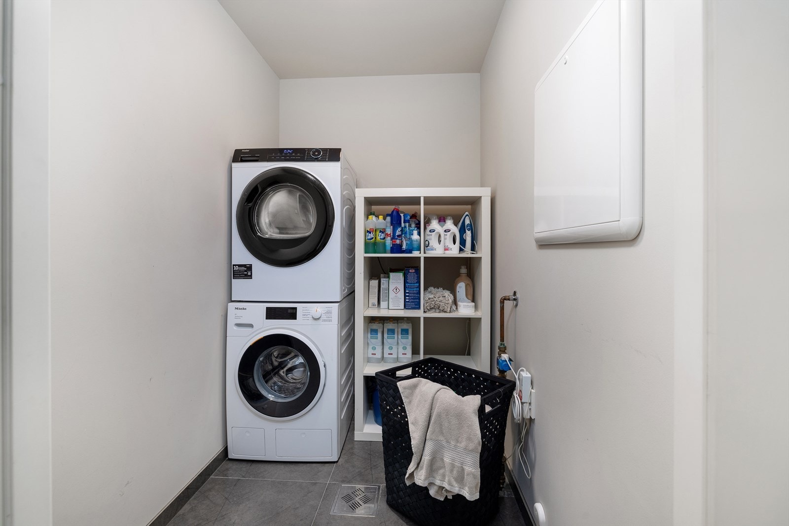 Et praktisk vaskerom med flislagt gulv og elektriske varmekabler, samt malte vegger og tak. Rommet har opplegg for vaskemaskin. Galleribilde