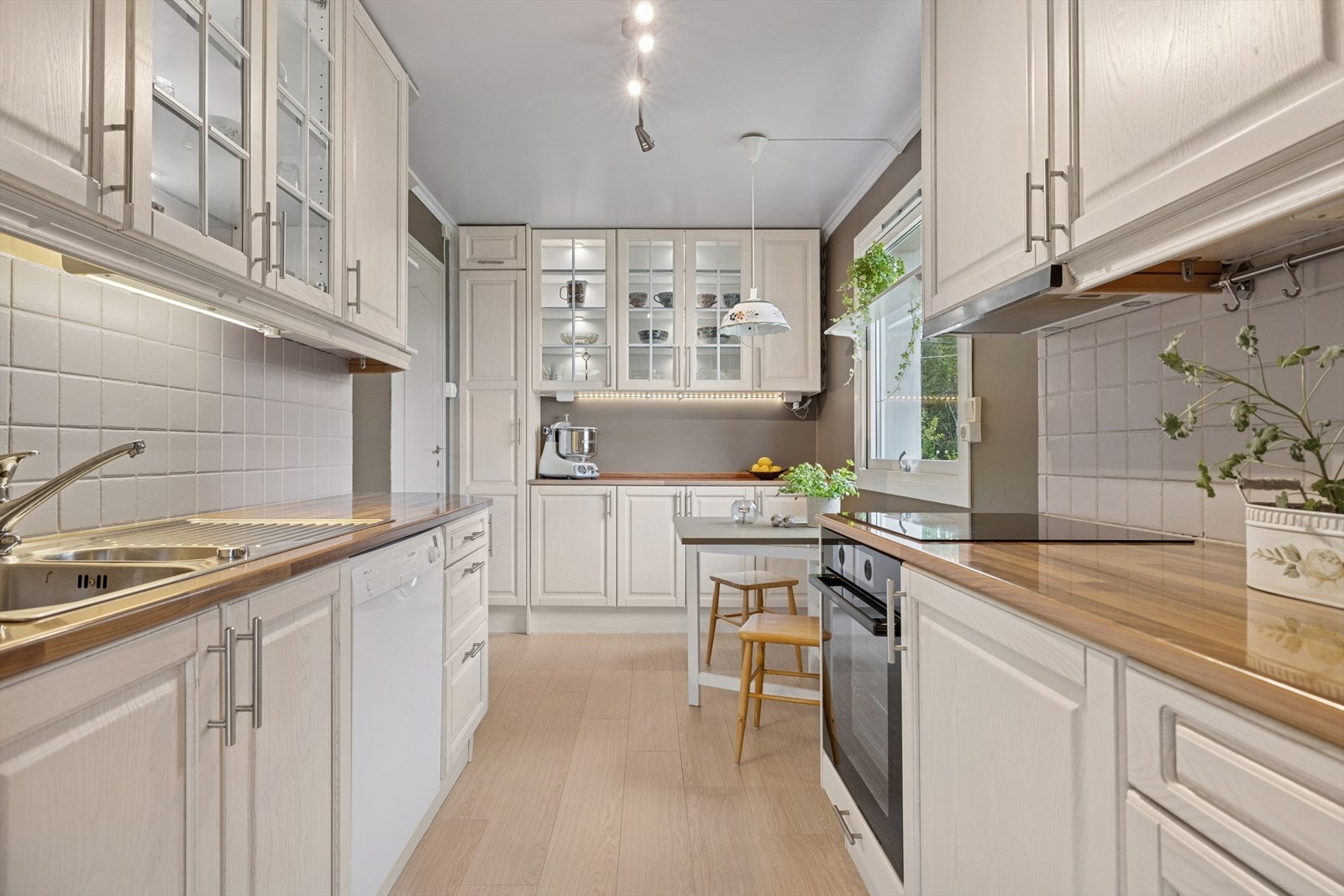 Kjøkkenet er utstyrt med stålkum, flis på vegg under overskap. Mekanisk avtrekkshette over platetopp med avtrekk ført ut i yttervegg. Komfyr med platetopp er integrert, og det er opplegg for kjøleskap og oppvaskmaskin. Galleribilde