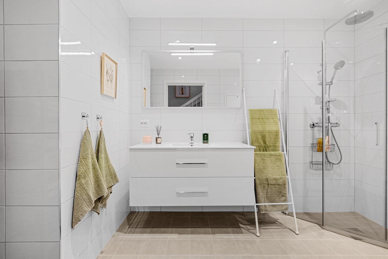 Badet er utstyrt med veggmontert toalett, dusjhjørne med glassvegger og baderomsinnredning med nedfelt servant. Det er klargjort for opplegg til vaskemaskin. Galleribilde