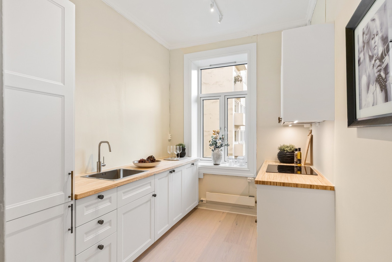 Fint, separat kjøkken med glatte fronter på skuffer og skap, og benkeplater i bambus. Galleribilde