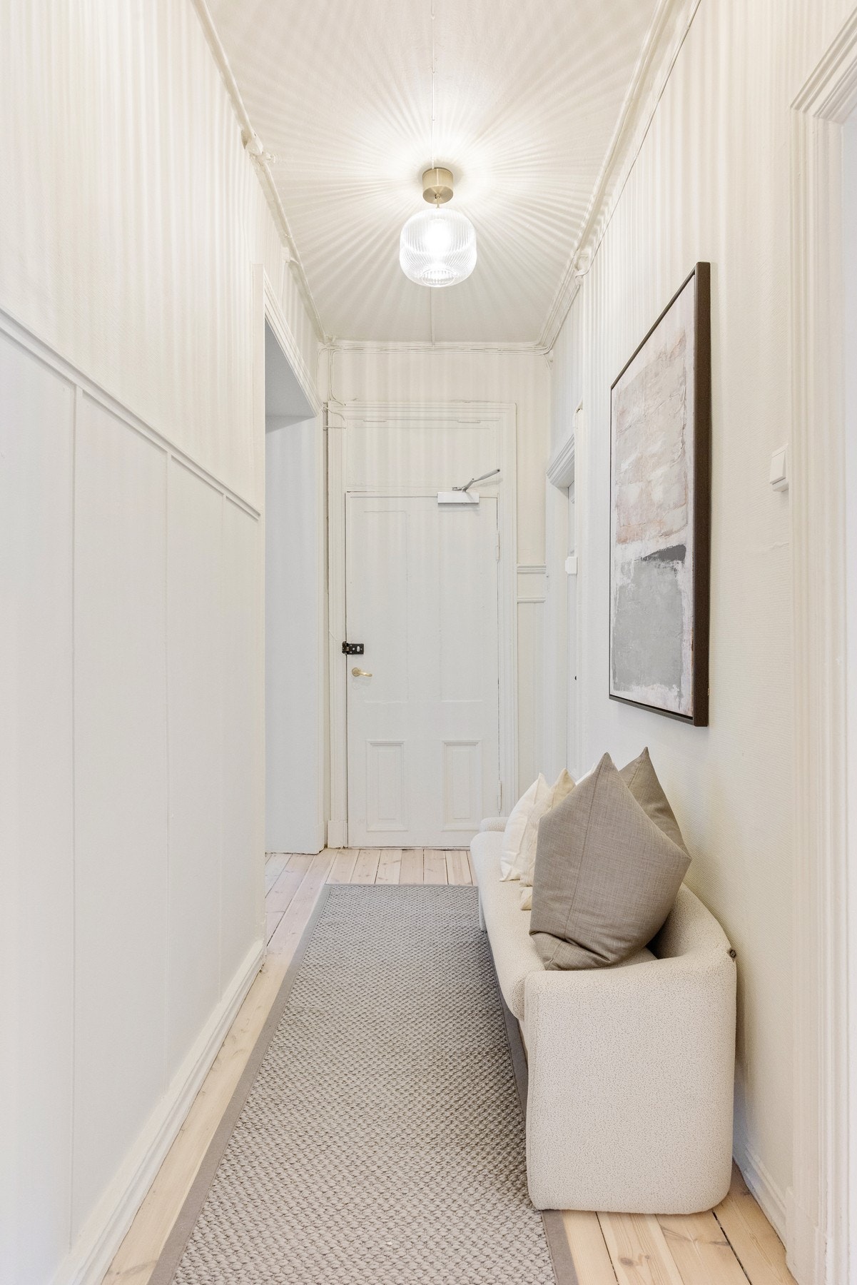 Innbydende entré med plass til yttertøy og sko. Dørcalling med åpner. Galleribilde