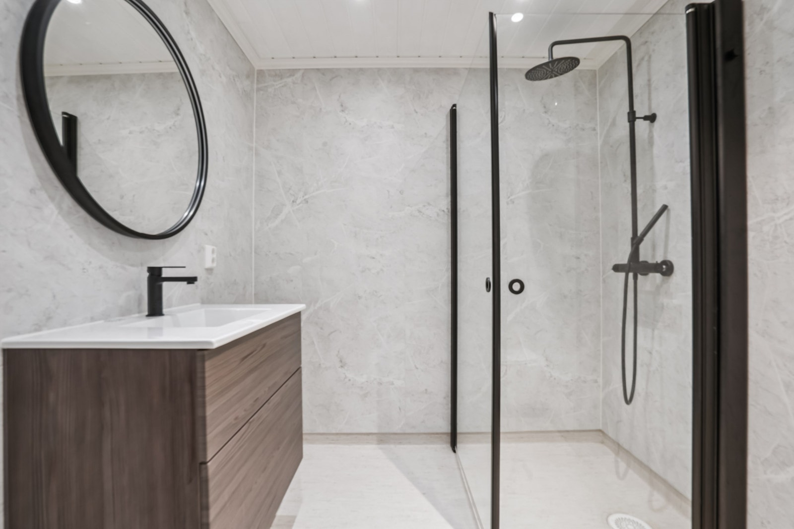 Badet er oppgradert med moderne baderomsplater og en stilren innredning med nedfelt servant. Galleribilde