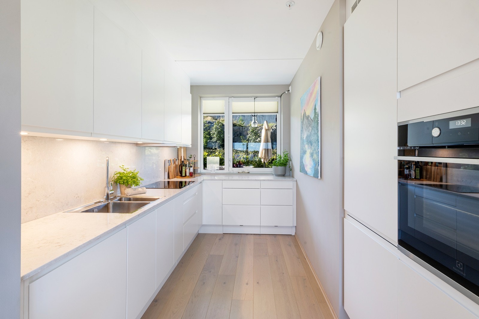 Pent kjøkken fra HTH med integrerte hvitevarer som Simens oppvaskmaskin, koketopp, kjøl/frys.Elextrolux ovn. Benkeplate og backsplash Caesarstone Bianco. Galleribilde