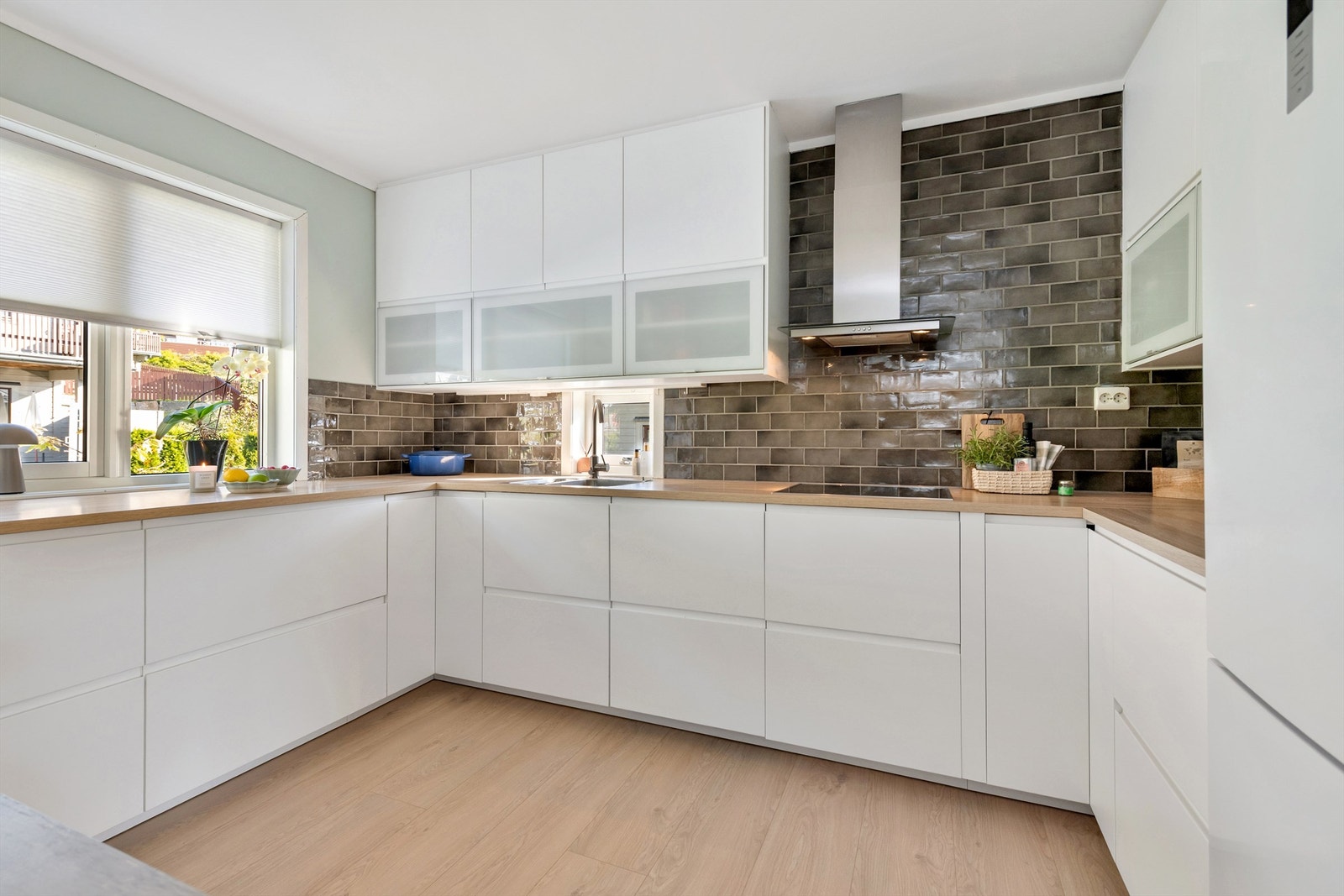 Ikea kjøkkeninnredning fra 2017 med profilerte fronter og benkeplate av laminat med nedfelt oppvaskkum med ett-greps kjøkkenarmatur. Galleribilde