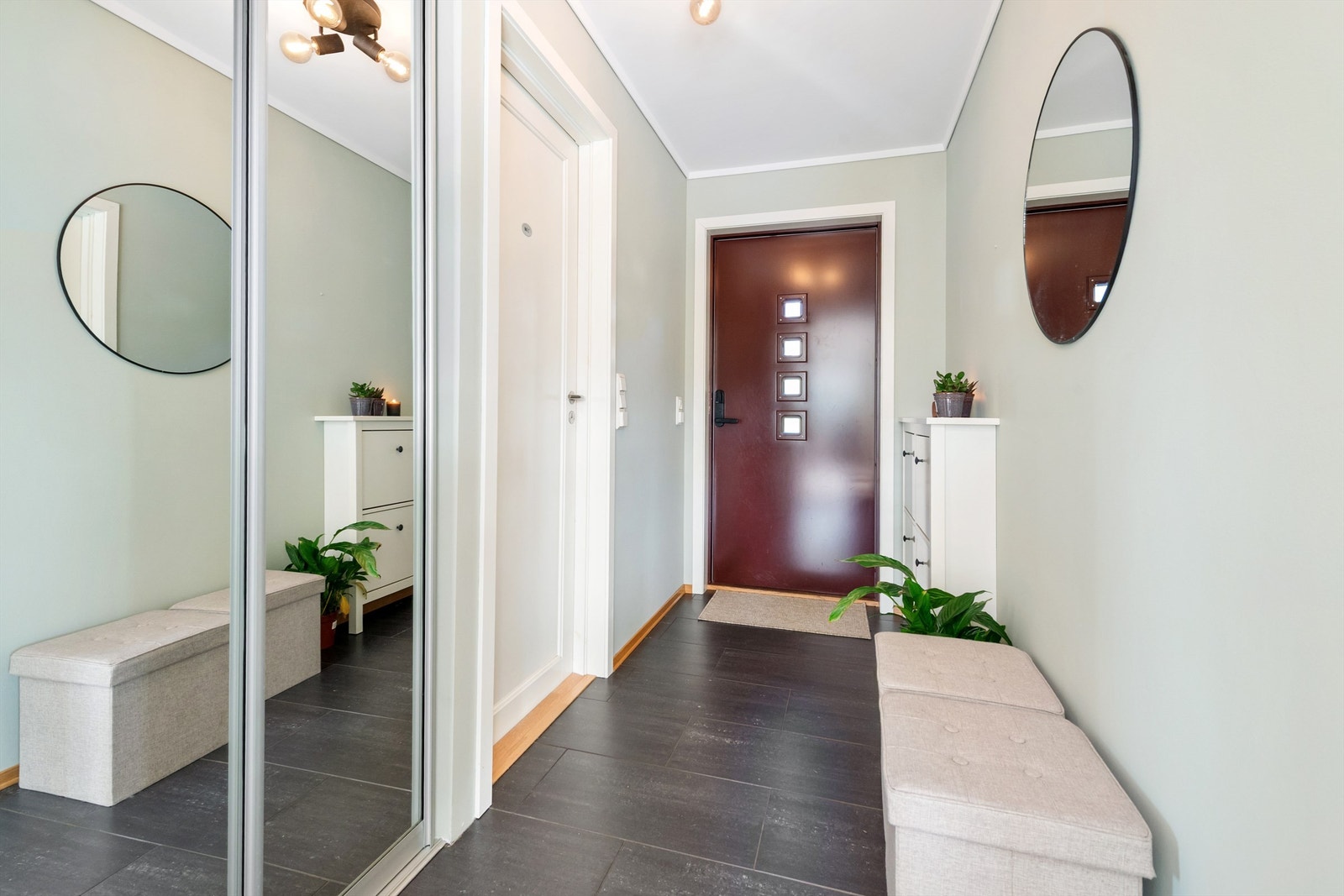 Entre med flislagt gulv med gulvvarme. Skyvedørsgarderobe med speilfronter for oppbevaring av yttertøy Galleribilde