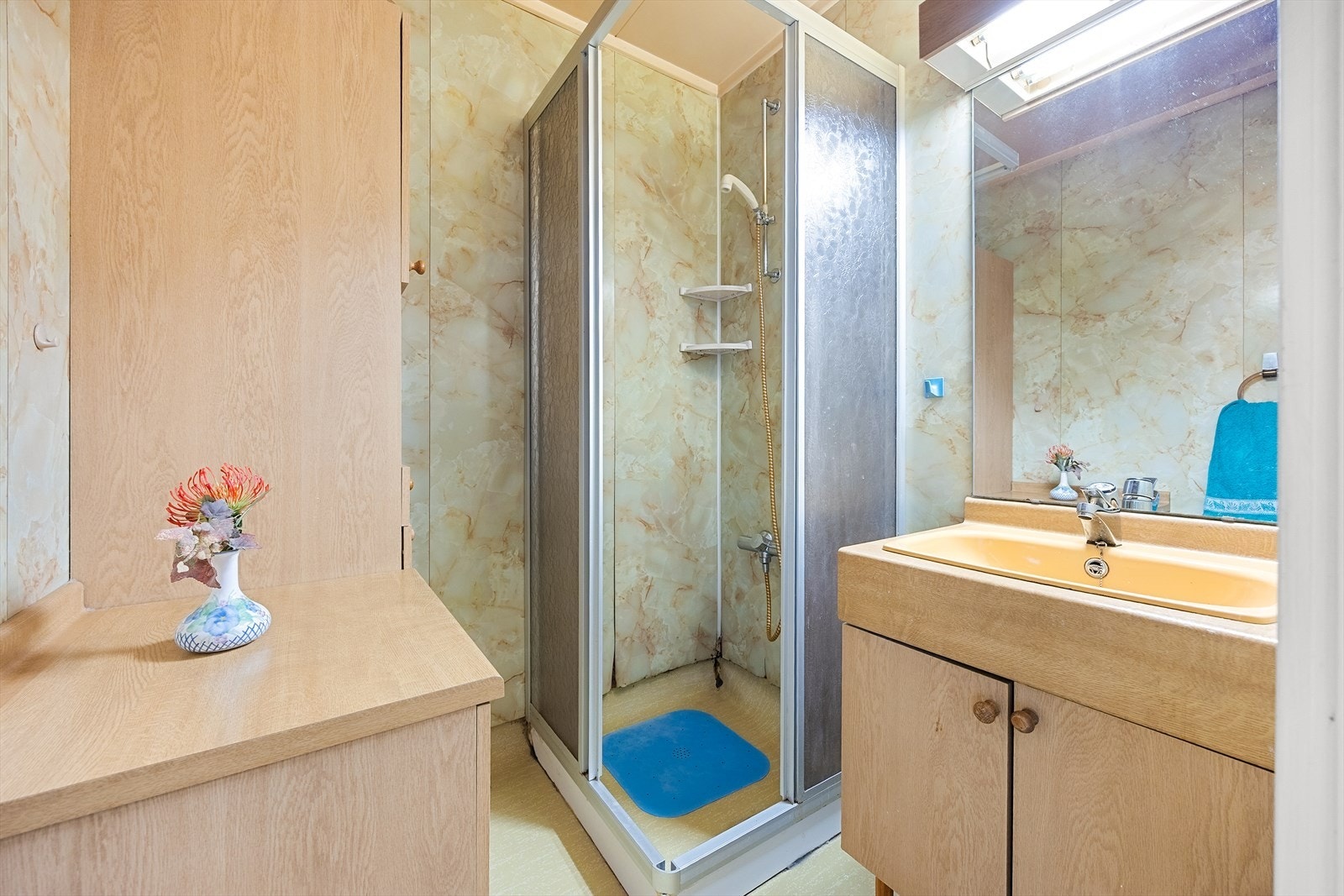 Bad med servantskap, speil og dusjhjørne med dører. Galleribilde