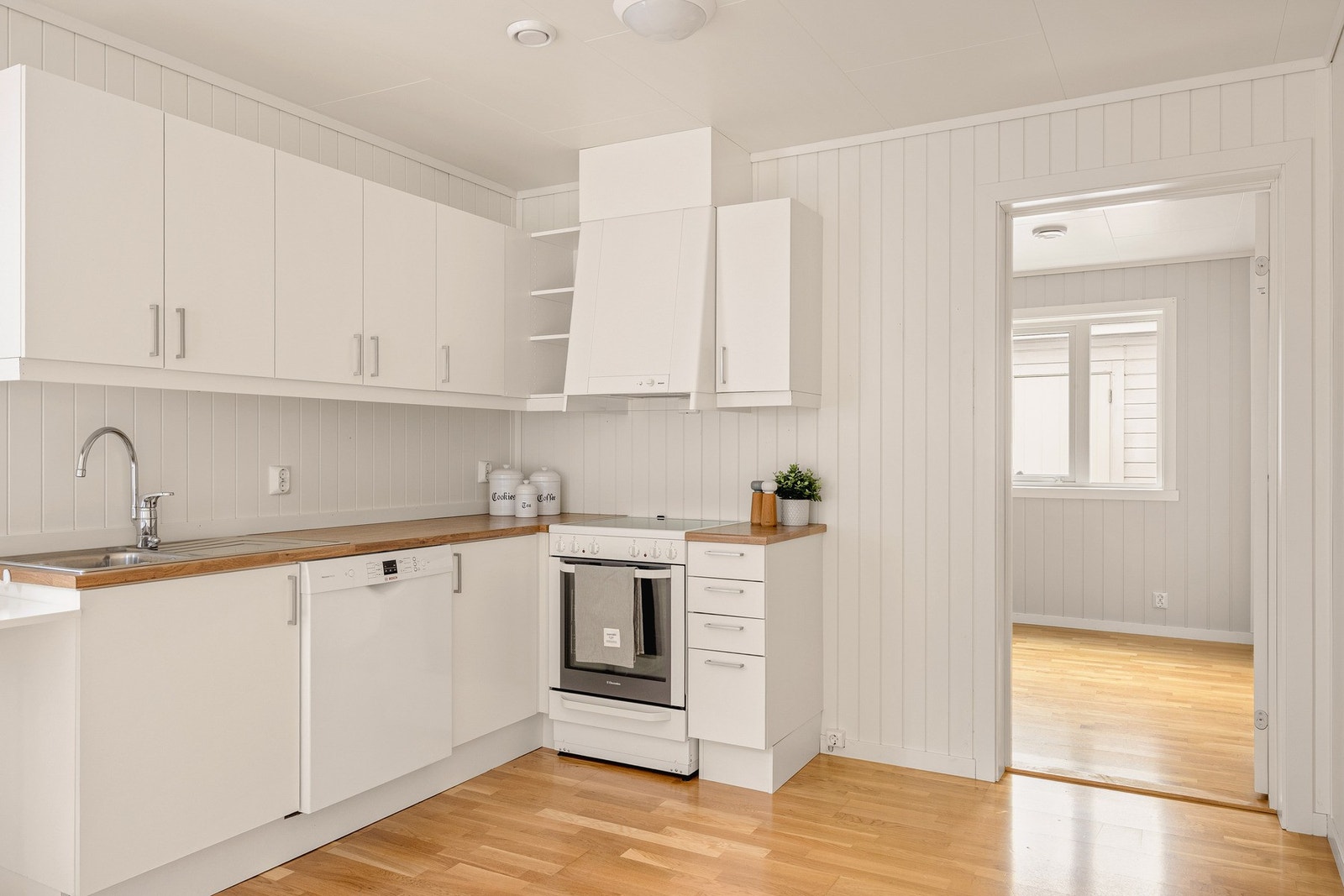 Kjøkkenet er fra Sigdal og har slette hvite fronter og laminat benkeplate med nedfelt vask av stål, samt plass/opplegg for kjøleskap, komfyr og oppvaskmaskin. Galleribilde