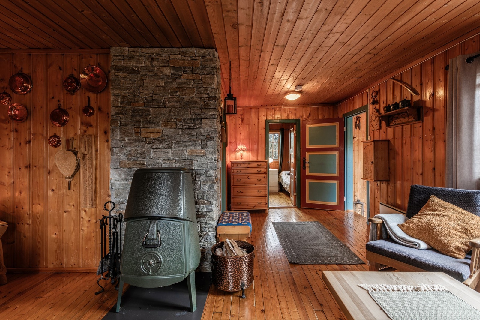 Klassisk teglsteinspipe er forblendet med skiferpaneler blir et naturlig midtpunkt som gir både varme og ekstra hyttekos. Galleribilde