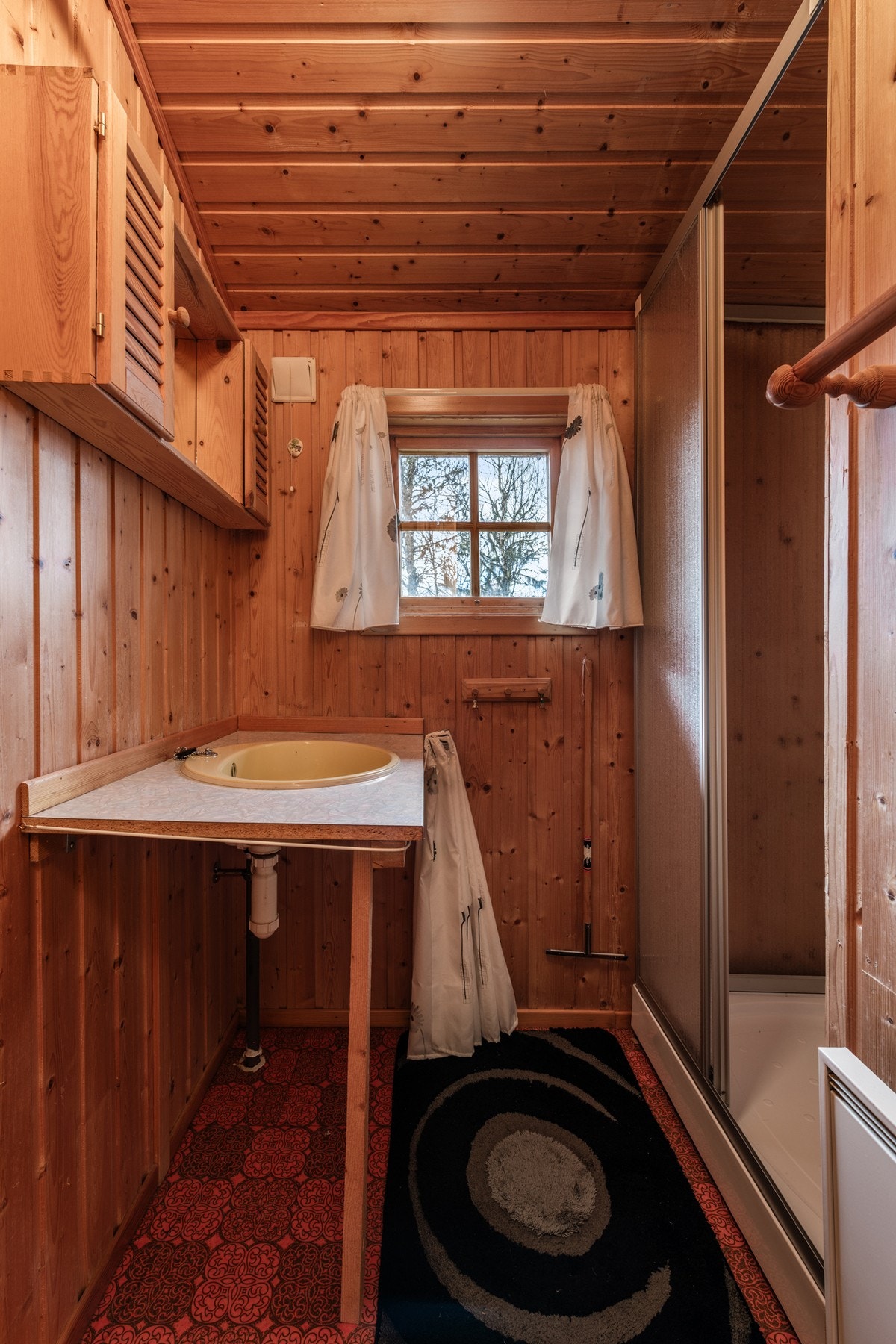 Badet er innredet med servant med overskap med speil og et praktisk dusjkabinett med pumpedusjløsning. Galleribilde