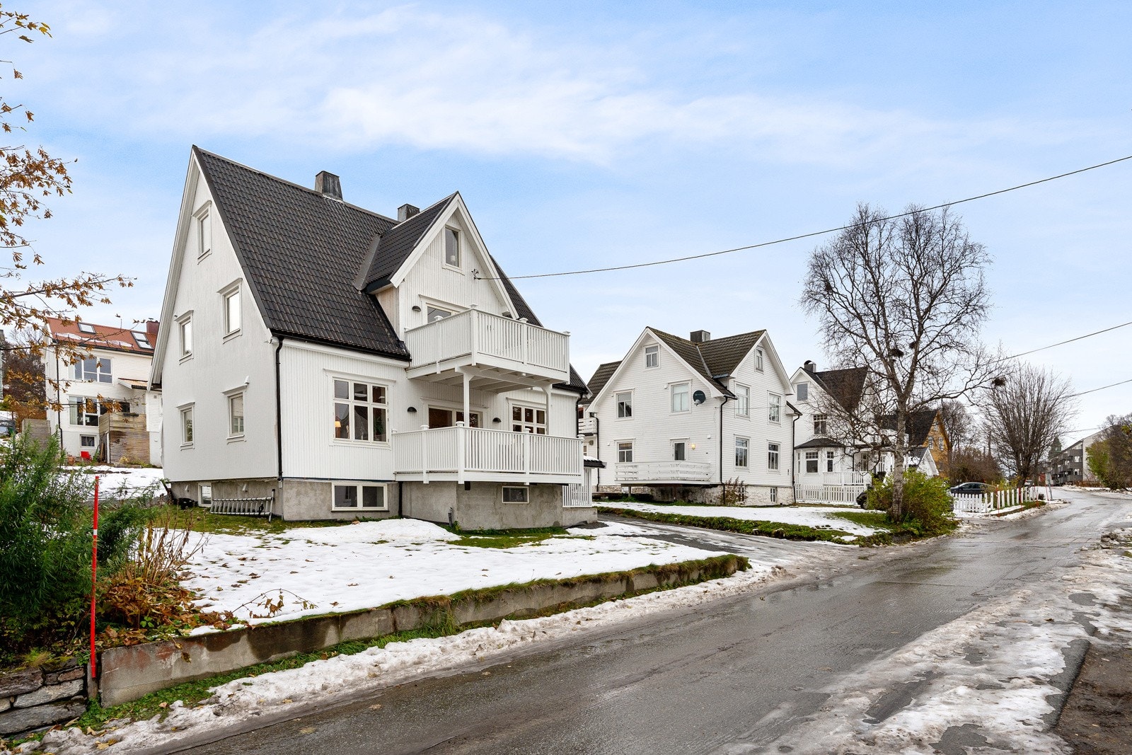 Eiendomstomt med stor hage med plen, enkel garasje og rikelig med oppstillingsplasser for bil i innkjørselen.