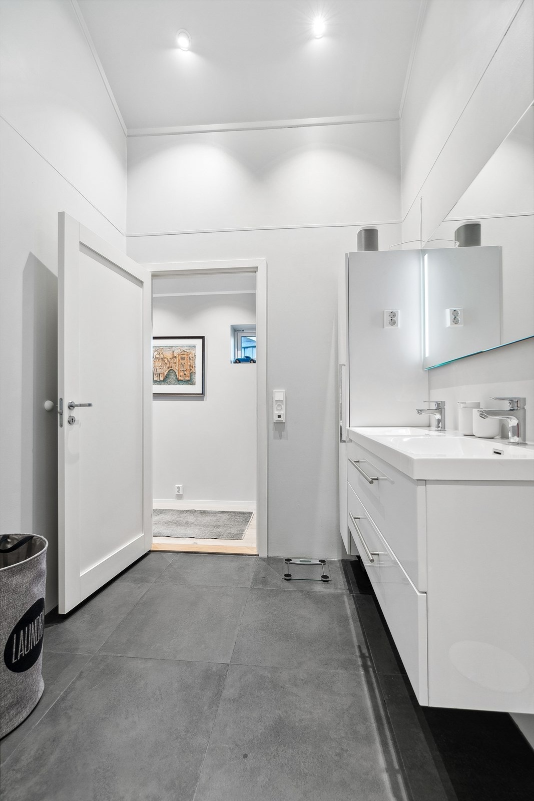 Lys og moderne baderomsinnredning med mye oppbevaringsplass. Det er varmekabler i gulv. Galleribilde