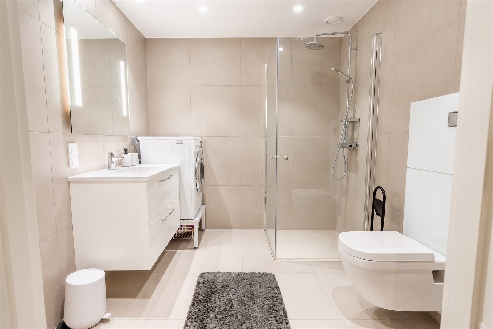 Delikat bad, med spotter i tak. Store fliser på gulv og vegger. Galleribilde