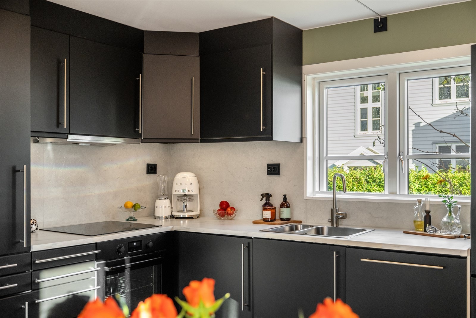 Kjøkkeninnredning med glatte fronter og benkeplate i laminert spon. Det er integrert oppvaskmaskin, platetopp og stekeovn. Kjøl/frys kan også medfølge. Galleribilde