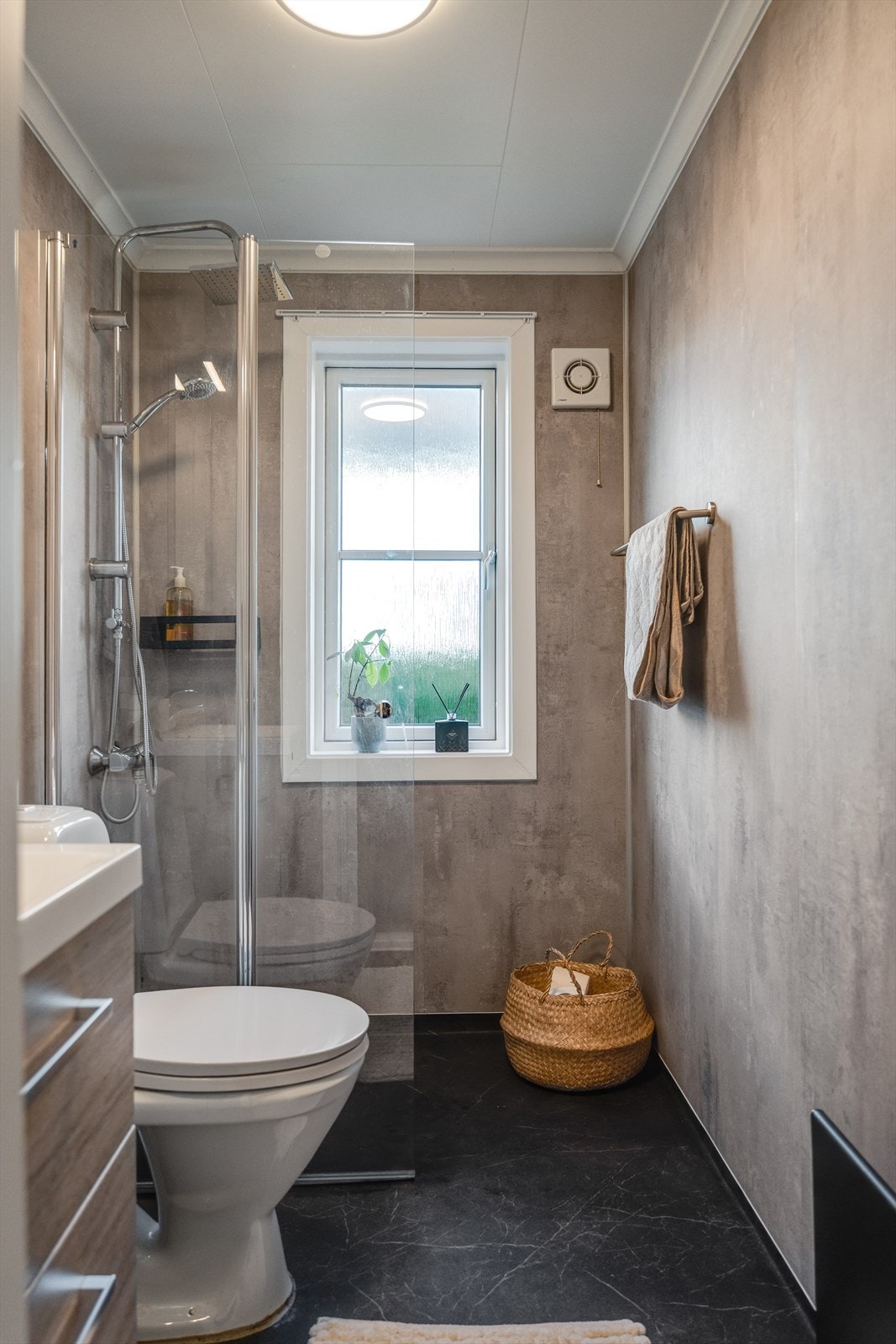 Pent baderom med dusjnisje, skuffeseksjon med servant, speil og toalett. Mekanisk avtrekk. Galleribilde