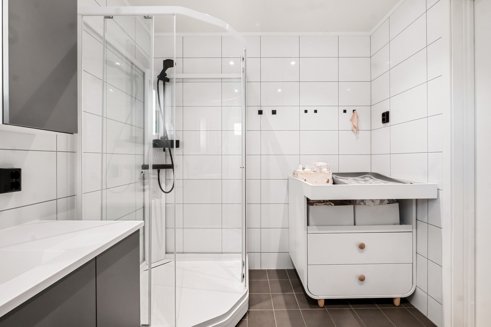 Romslig bad med plass til både møblering og smarte oppbevaringsløsninger Galleribilde