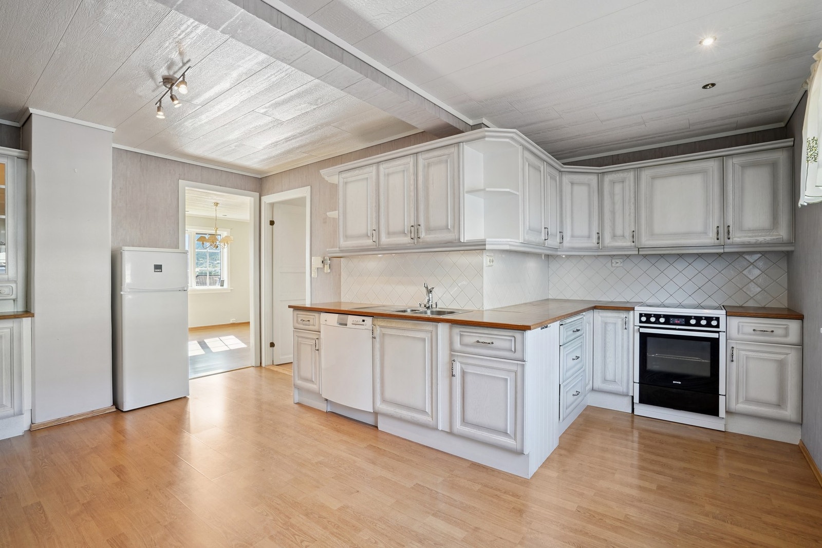 Romslig kjøkkeninnredning med både over- og underskap. Galleribilde