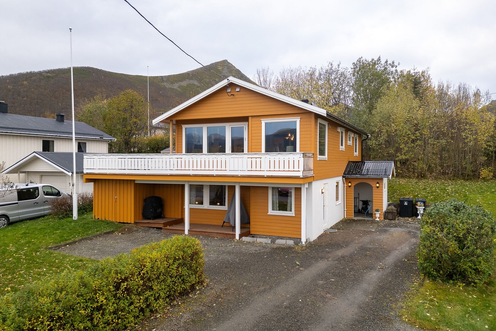 Parkering på gruslagt gårdsplass med el-bil lader montert. I 2024 ble det lagt ny vindsperre og bordkledning på 1. etasje, samt nye vindskibord og takrenner. Galleribilde