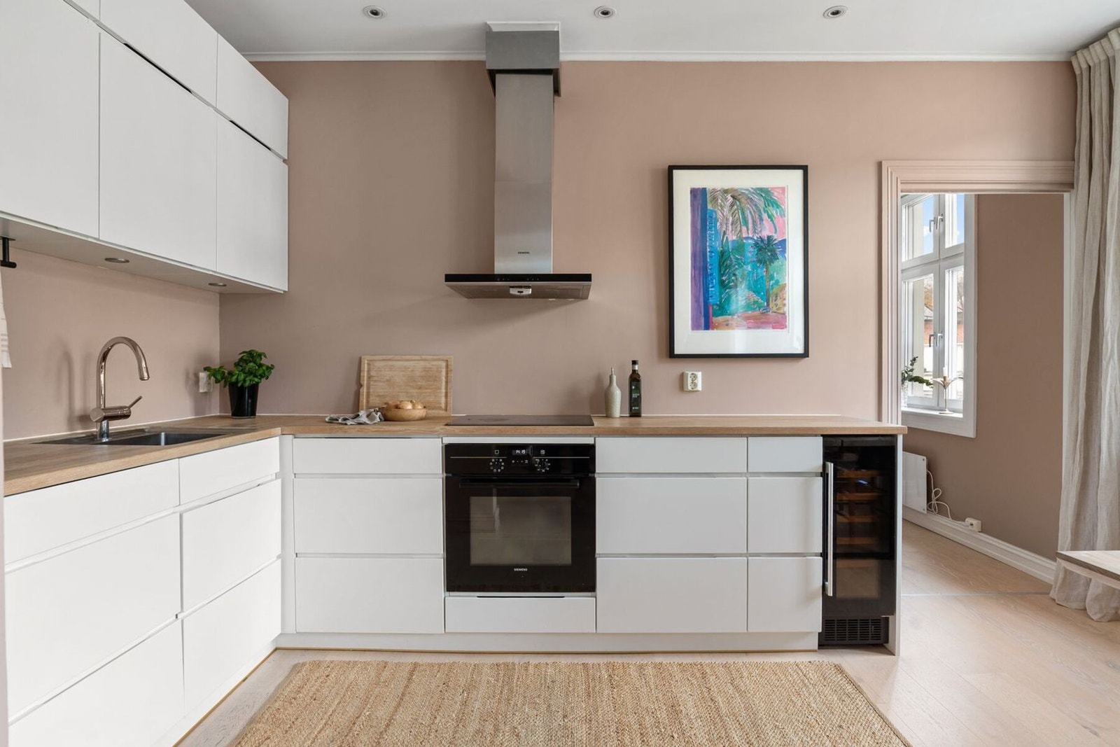 Kjøkken fra 2015 innredet med slette fronter og benkeplate av heltre. Galleribilde