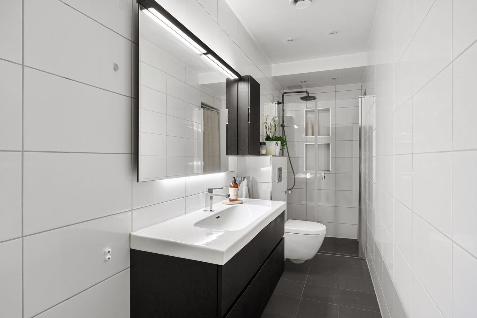 Delikat flislagt baderom fra 2015 med varme i gulv. Det er opplegg for vaskemaskin og tørketrommel på badet. Galleribilde