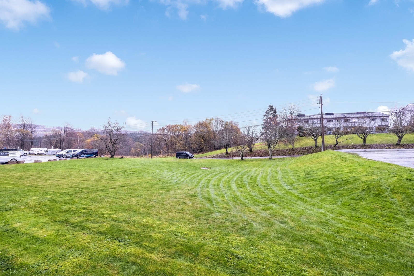 Tomten er pent opparbeidet med plen i forkant av blokkene. Galleribilde