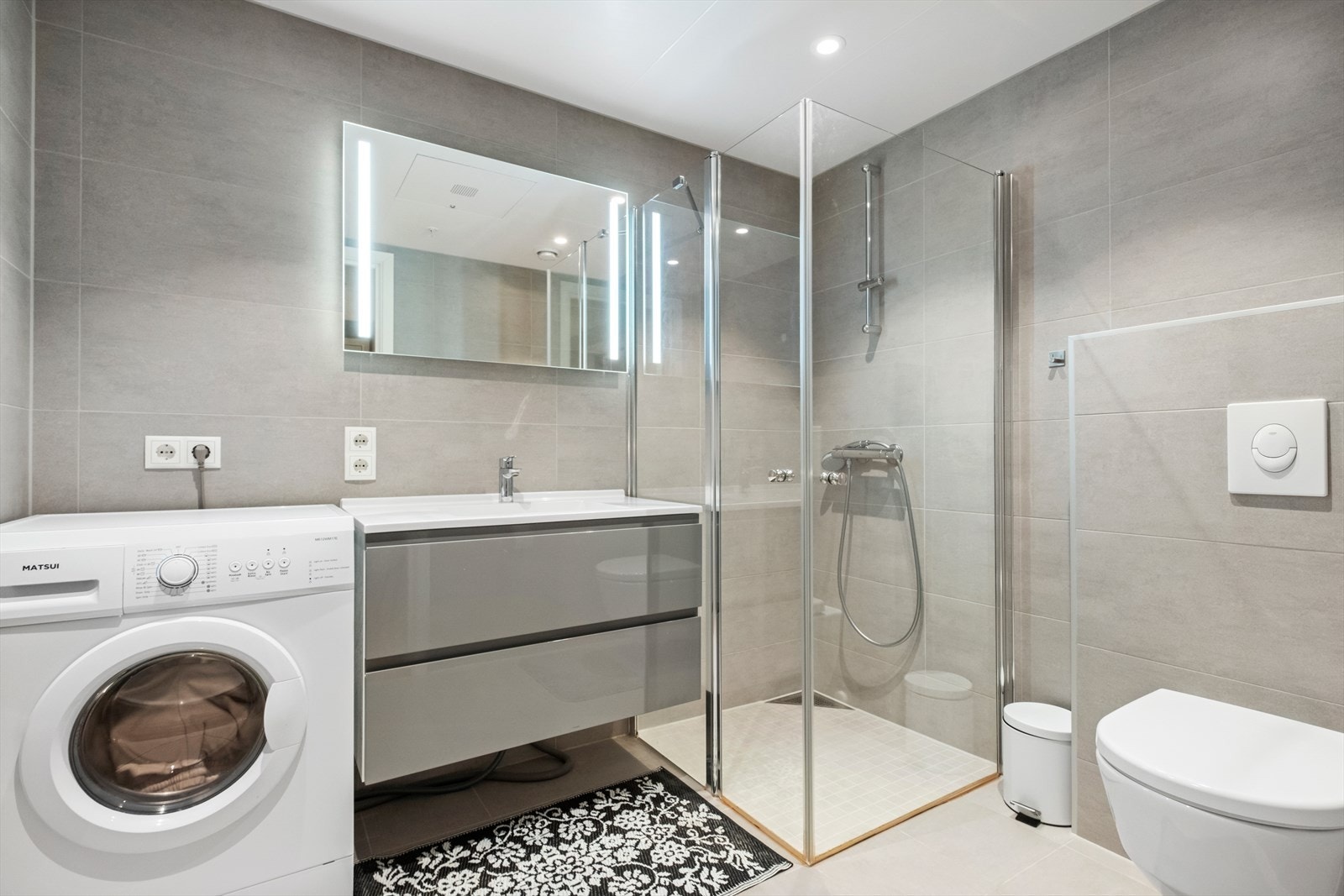 Lyst helfliset bad, med varmekabler på gulv. Galleribilde