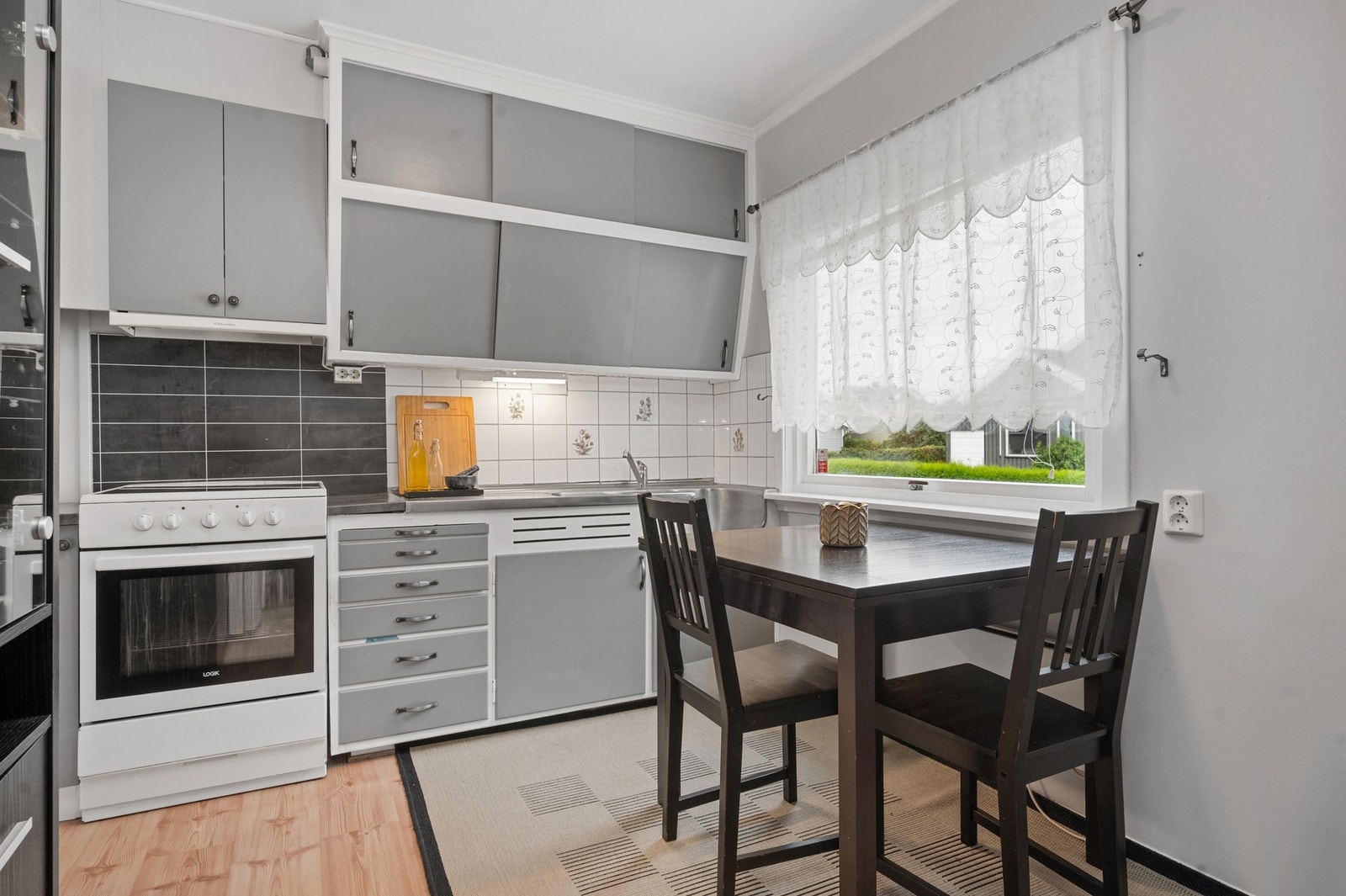 Eldre kjøkken med spiseplass og vindu mot hagen Galleribilde