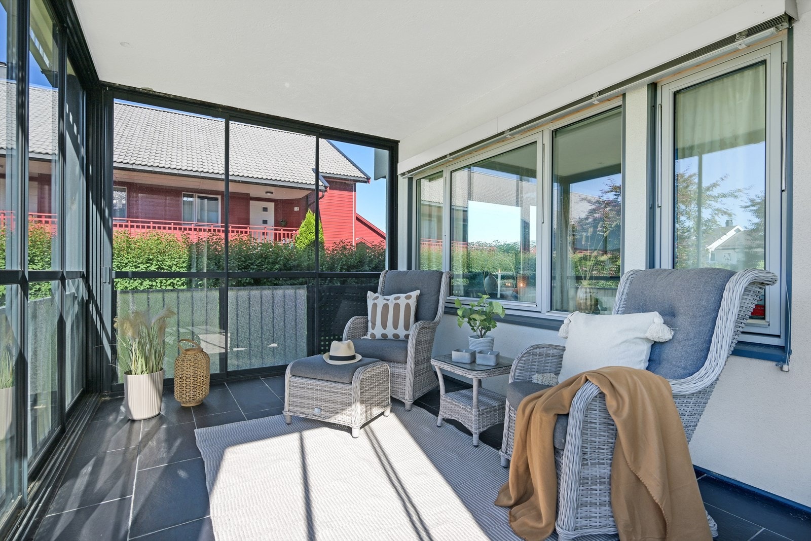 Innglasset terrasse med glassvegger og skyvedør som gir beskyttelse mot vær og vind, og gjør uteplassen brukbar store deler av året. Galleribilde