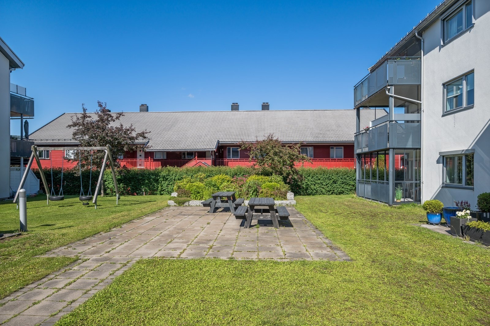 Tomten er pent opparbeidet med plen, trær og beplantede bed, og har steinsatt sti til inngangspartiet samt hellelagt sitteområde med benker. Galleribilde