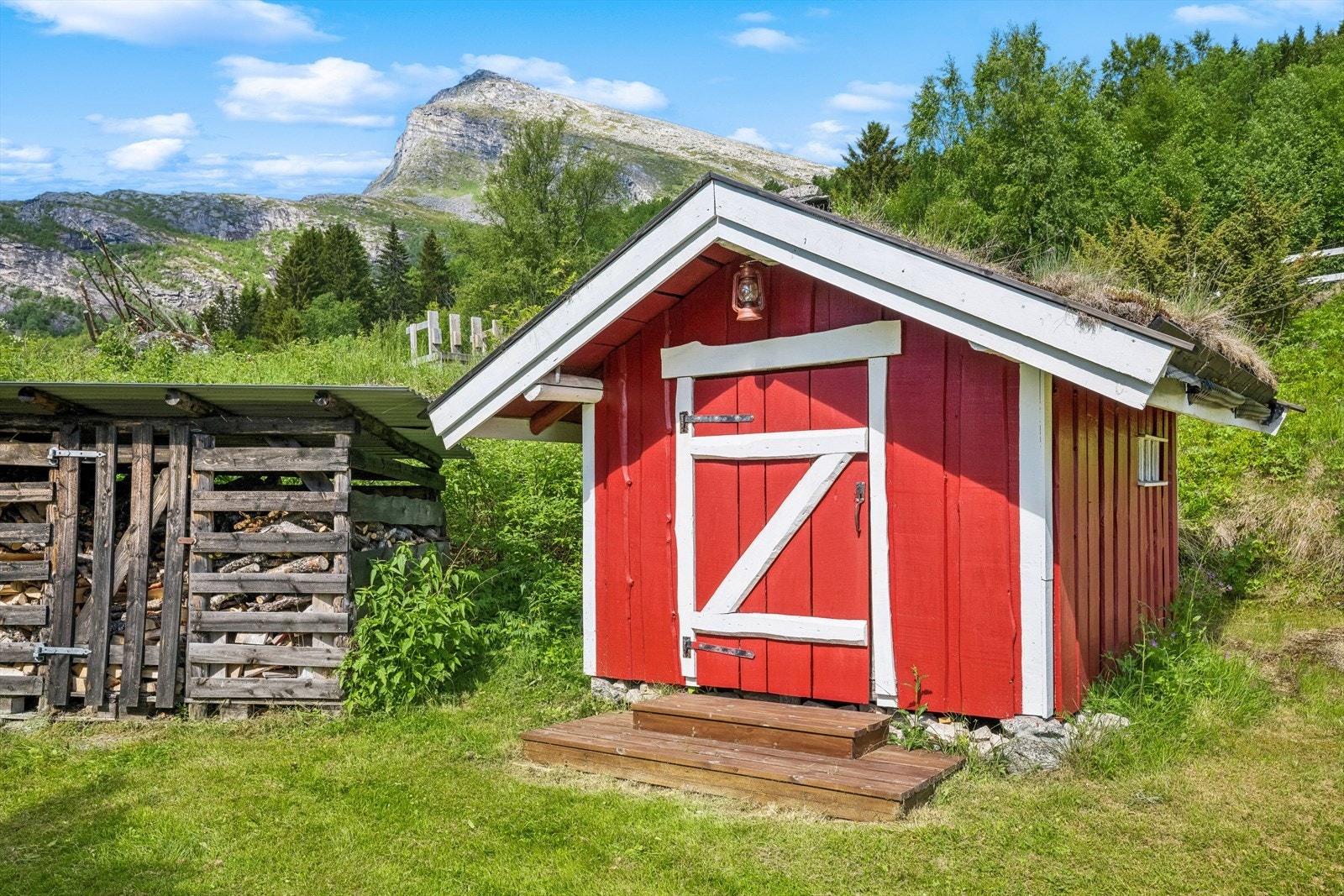 Vedskjul til venstre og fasade til frittstående badstu. Galleribilde