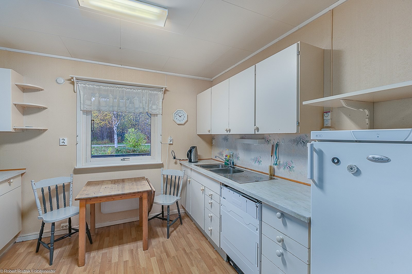 Eldre men fult fungerende kjøkkeninnredning med avsatt plass til hvitevarer. Galleribilde