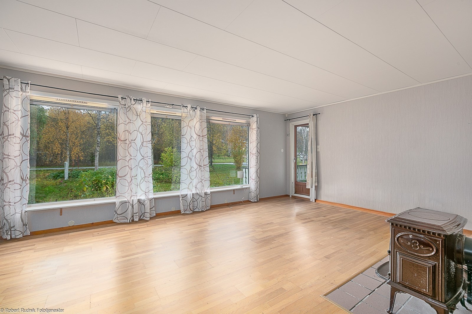 Romslig stue med store vindusflater og utgang til solrik veranda. Galleribilde