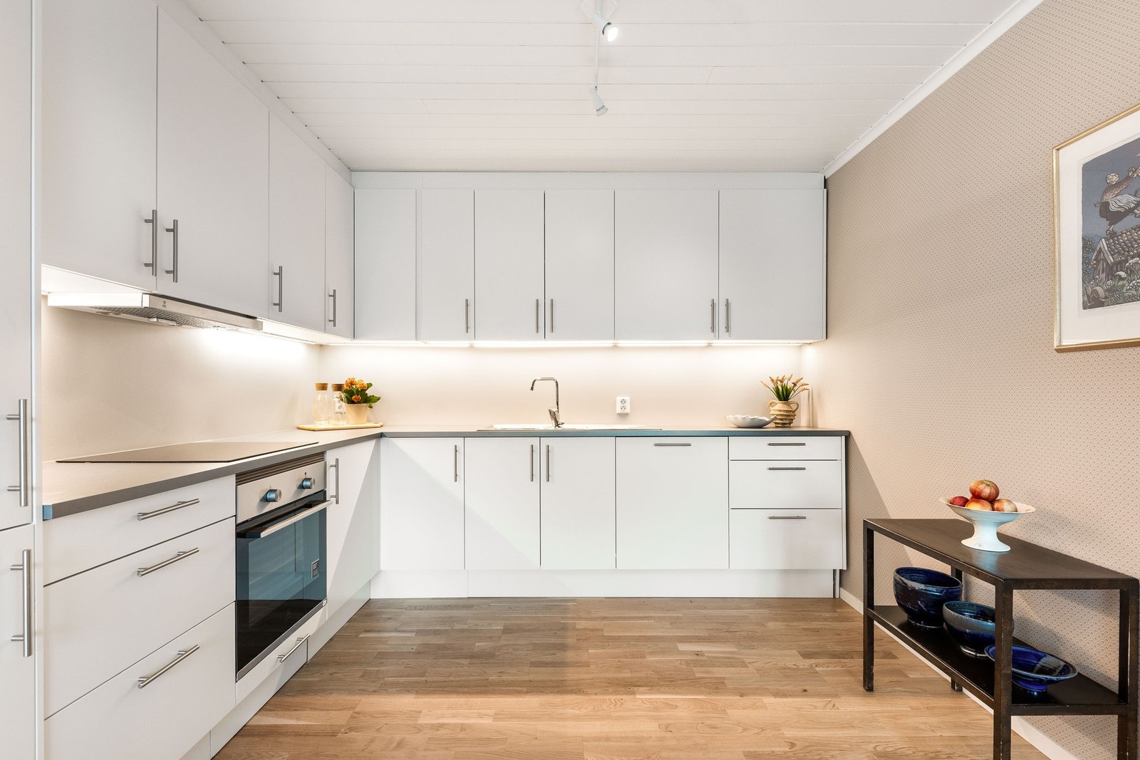 Lyst og moderne uttrykk med glatte, hvite fronter og integrerte hvitevarer. Galleribilde