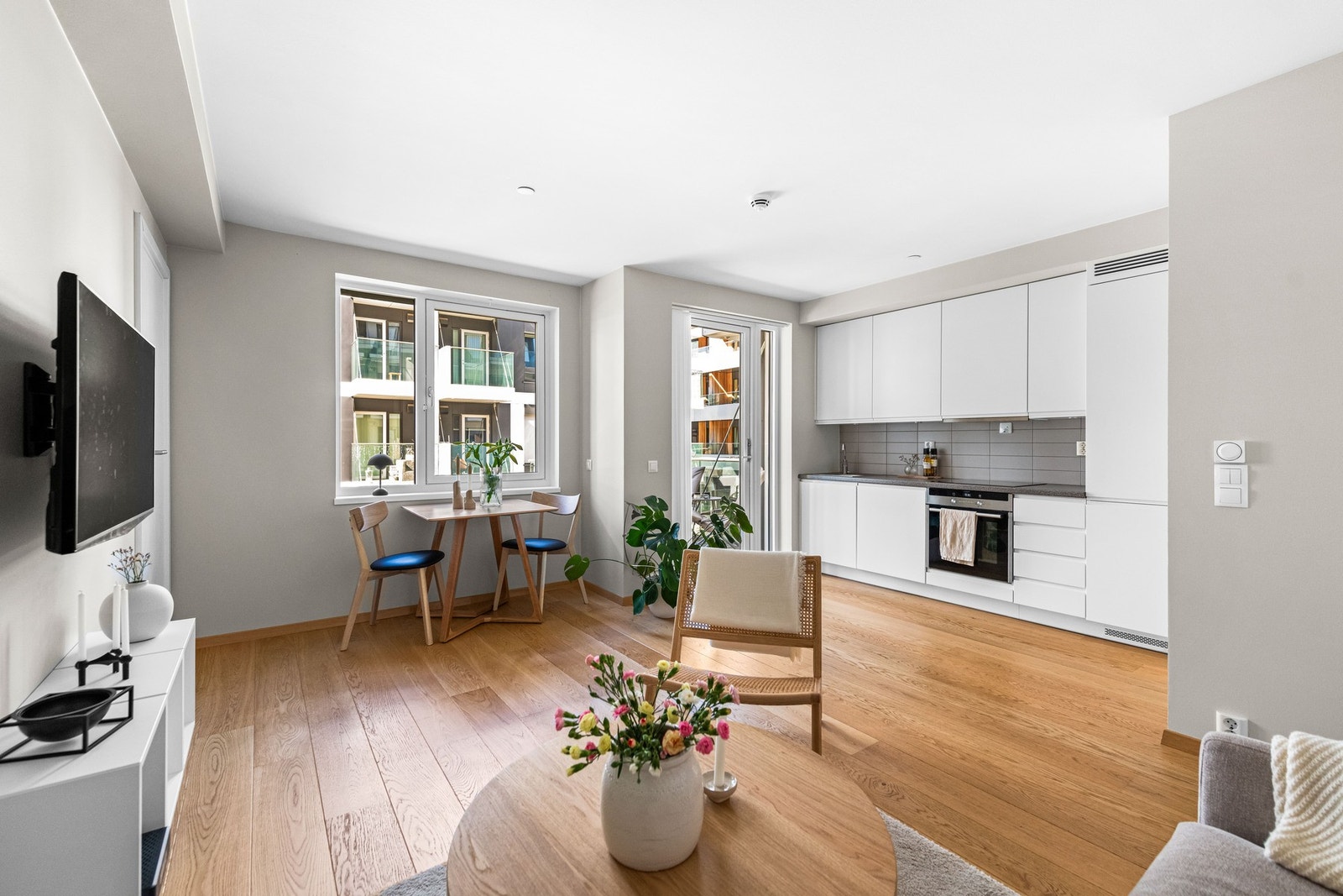 Kjøkkenet har hvite, glatte fronter, integrerte hvitevarer og god arbeidsplass, mens stuen har store vindusflater og utgang til balkongen. Galleribilde