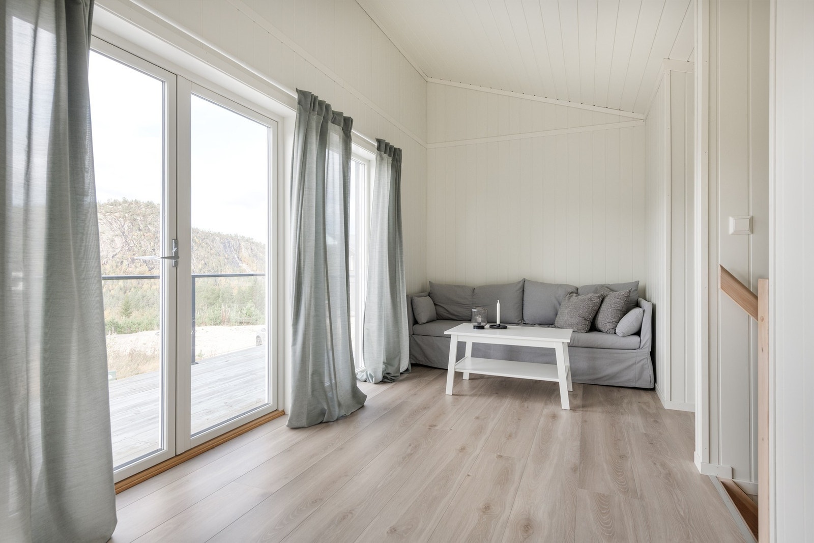 Lys TV-stue med utgang til solrik balkong Galleribilde