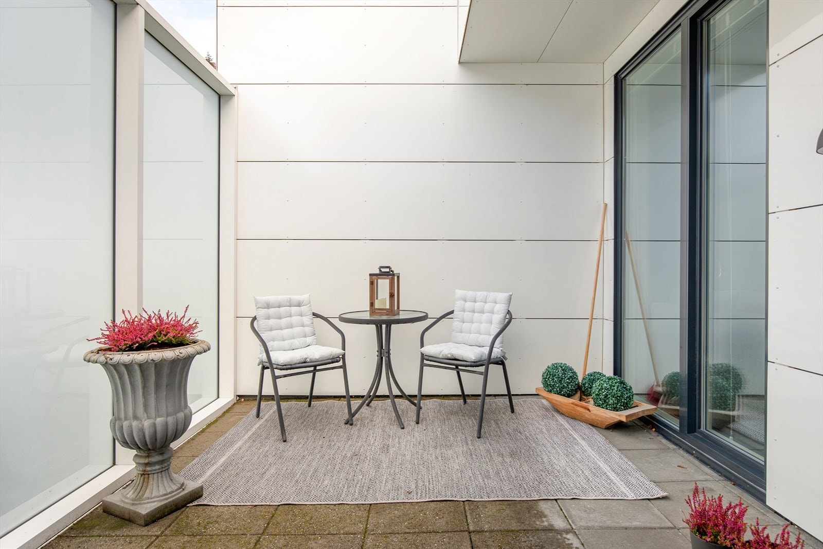 Koseleg inngangsparti der ein kan innrede med sittegrupper og beplanting. Her sit ein privat til frå resten av sameiget. Galleribilde