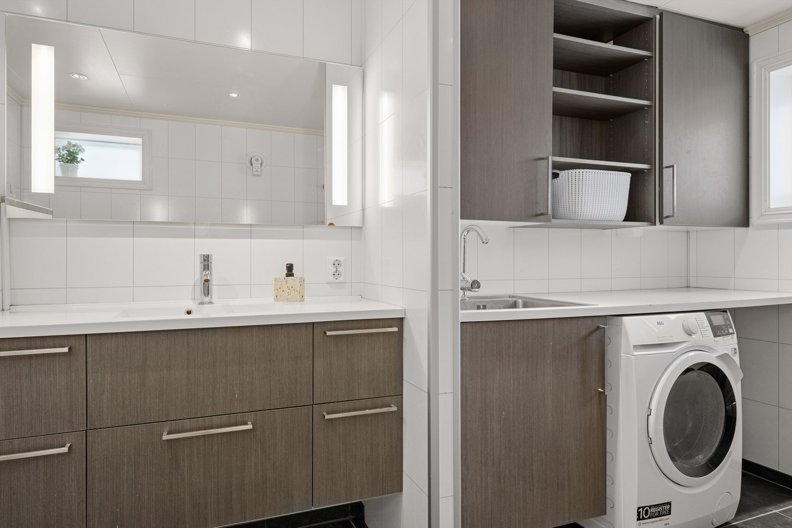 Badet er moderne og funksjonelt, med baderomsplater på veggene og fliser på gulvet som gir et stilrent og elegant uttrykk. Gulvet har varmekabler som sørger for en behagelig temperatur året rundt, noe som gjør det ekstra komfortabelt å bruke badet. Galleribilde