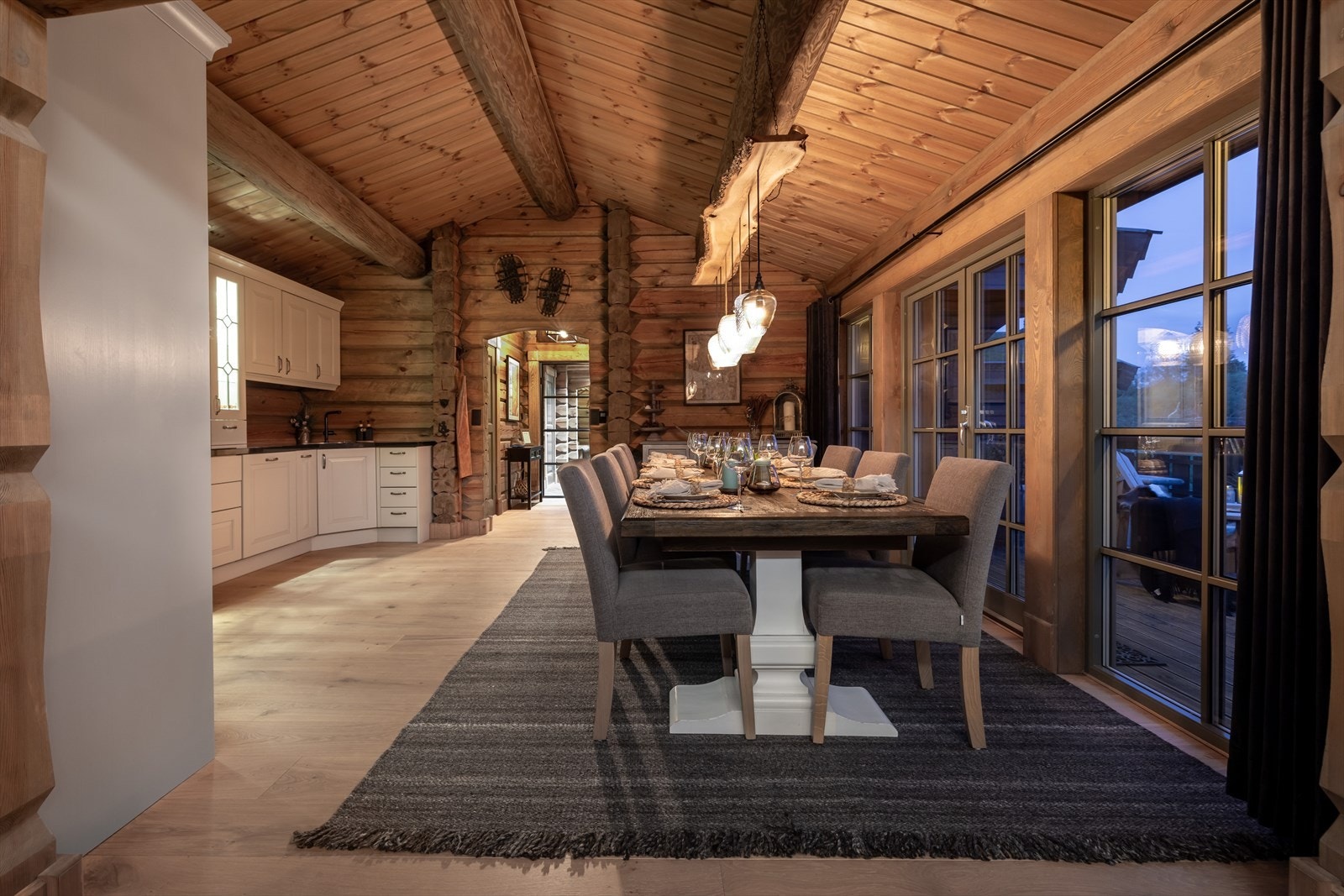 Romslig spisestue med åpen kjøkkenløsning og store vindusflater Galleribilde