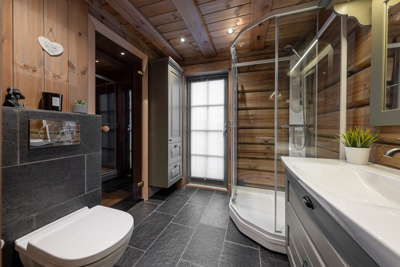 Bad 1 med flis på gulv og panel på vegg. Galleribilde