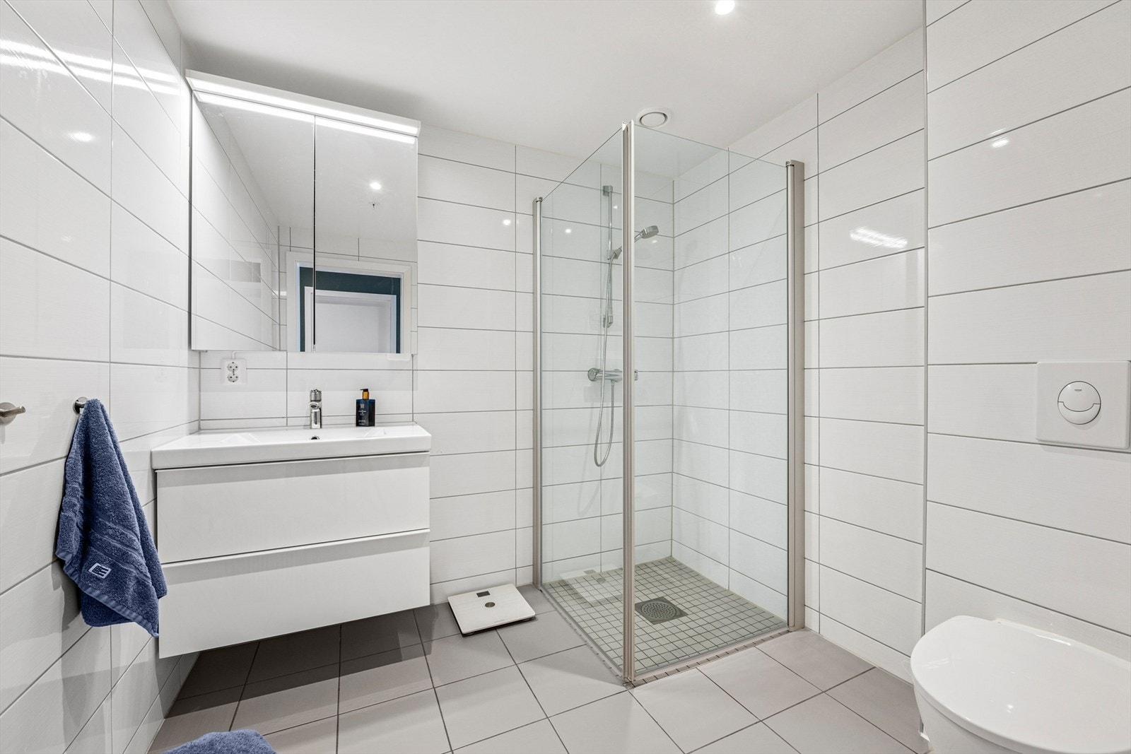 Fra gangen er det videre adkomst til leiligheten sitt andre baderom. Dette badet er i likhet med de øvrige rommene romslig og innbydende, med flislagt gulv og vegger. Galleribilde