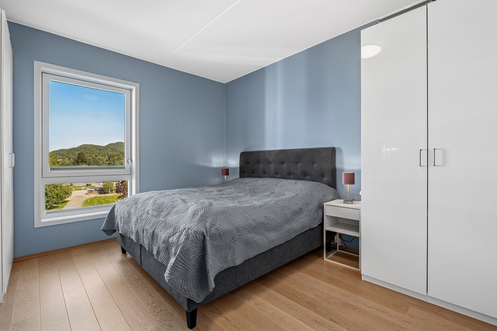 Leiligheten har tre luftige og flotte soverom. Her ser vi bilde fra hovedsoverommet som har en meget flott utførelse med flotte og gjennomtenkte farge- og materialvalg og er innredet med gode garderobeløsninger. Galleribilde