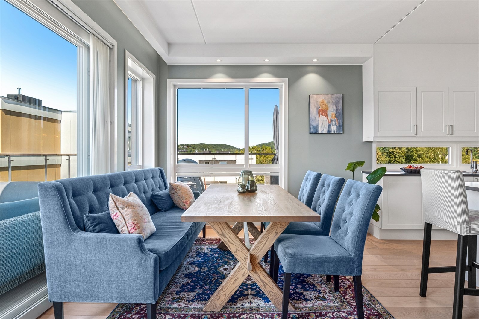 Rommet har store vinduer og skyvedør i glass som slipper inn godt med dagslys og sikrer den spektakulære sjøutsikten. Den luftige takhøyden understreker den lette stemningen. Galleribilde
