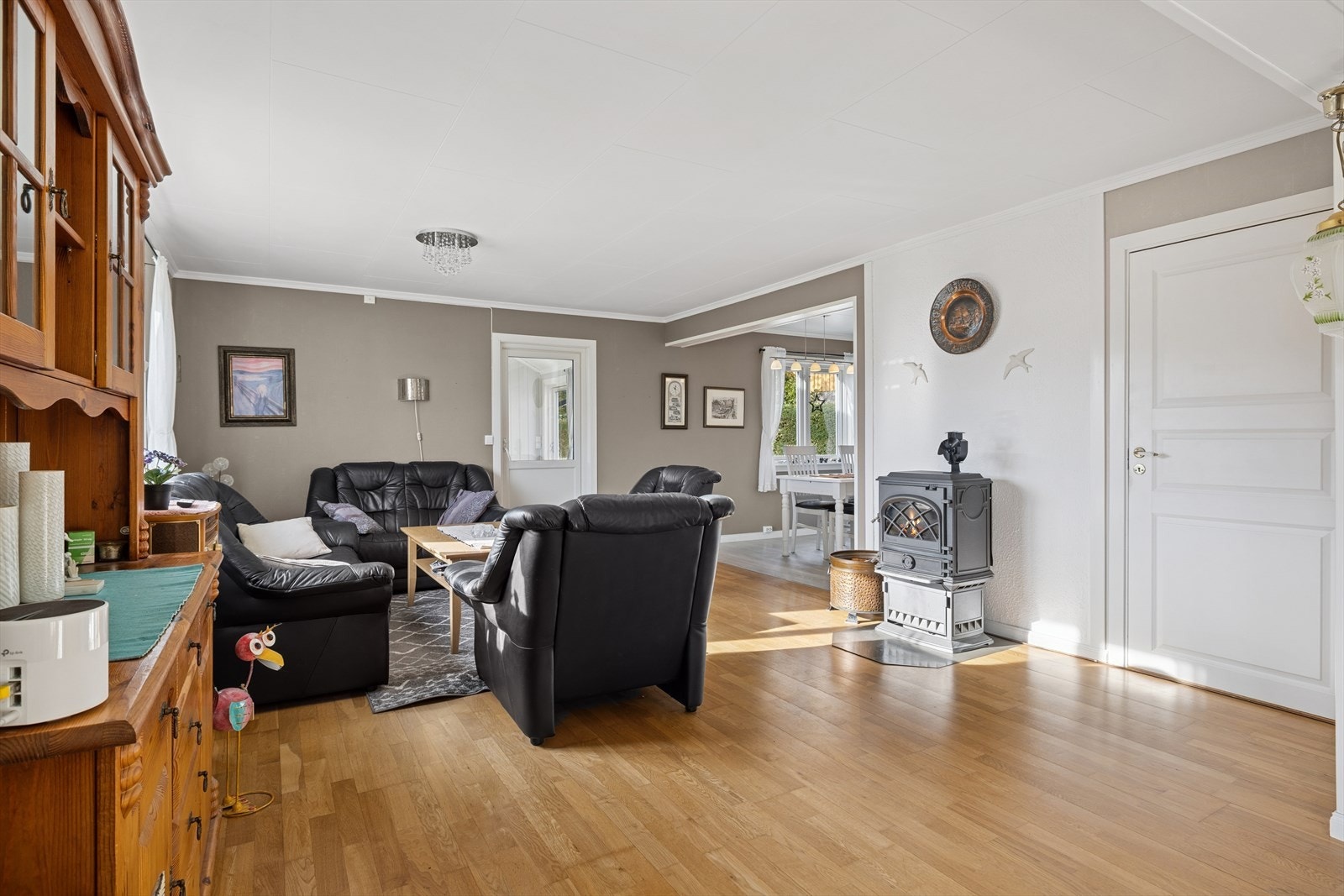 Lys og romslig stue med god plass til flere sofagrupper. I rommet er det montert en vedovn som gir både varme og hyggelig stemning på kjølige dager. Galleribilde