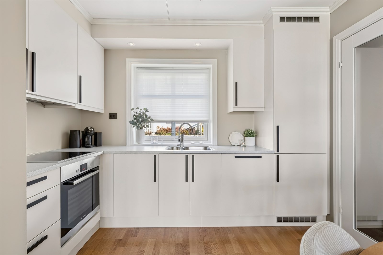 Stilrent og lekkert kjøkken innredet med folierte skrog med slette fronter og laminert benkeplate. Galleribilde