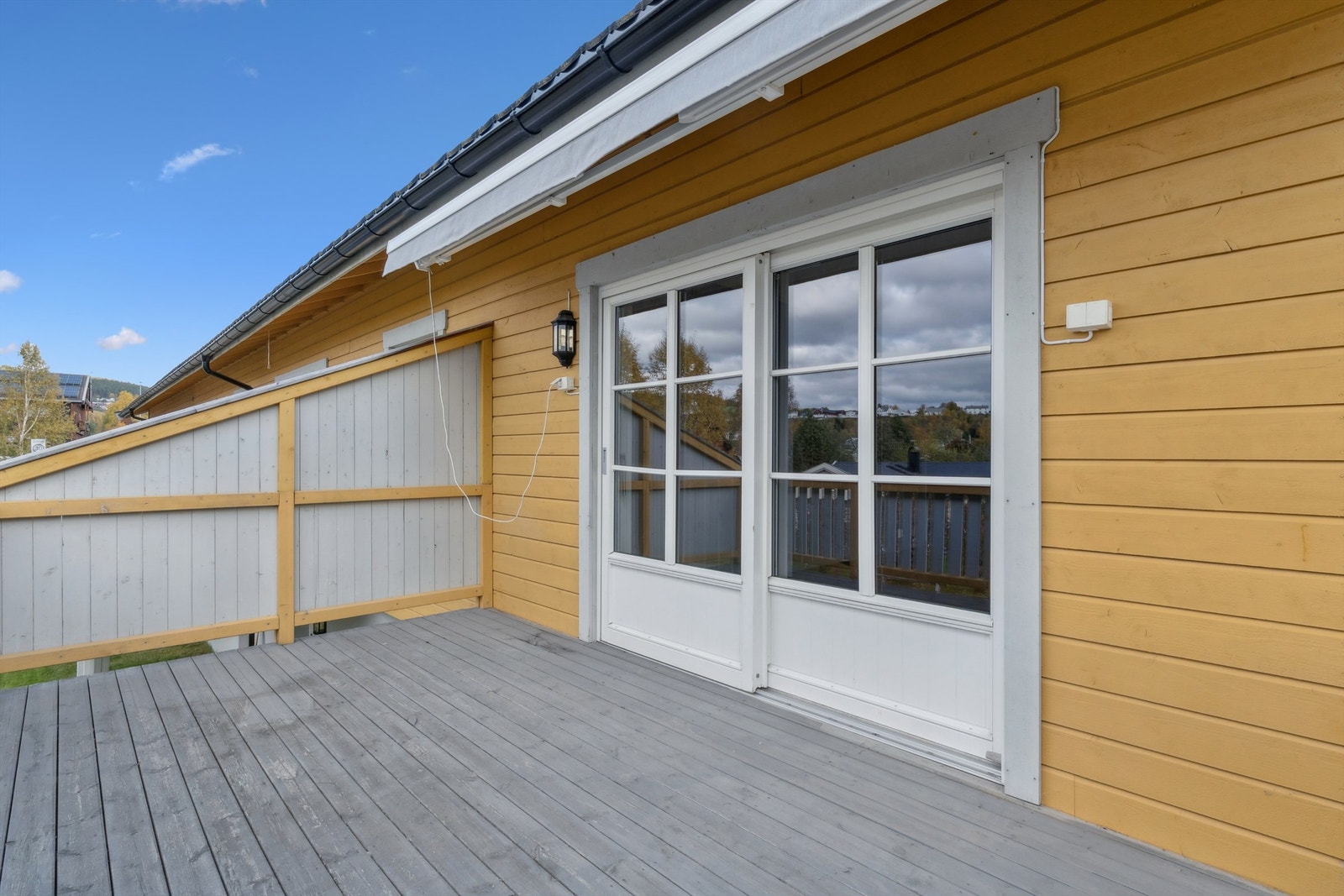 Verandaen er en fin forlengelse av stuen på sommerhalvåret. Elektrisk markise og praktisk skyvedør. Galleribilde