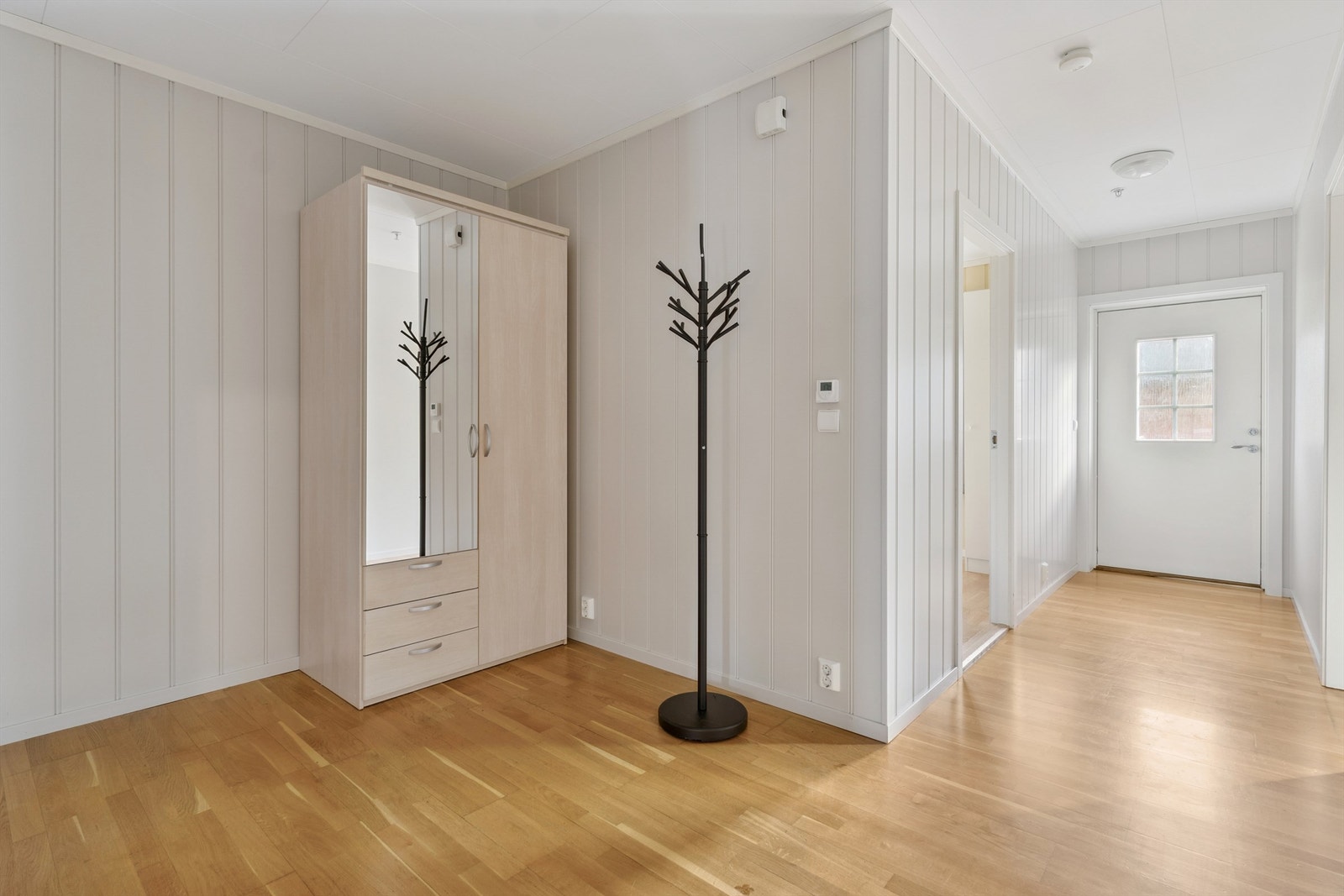 Boligen har enkel adkomst fra bakkeplan inn i en lys og romslig entré med fin plass til oppbevaringsløsninger. Galleribilde