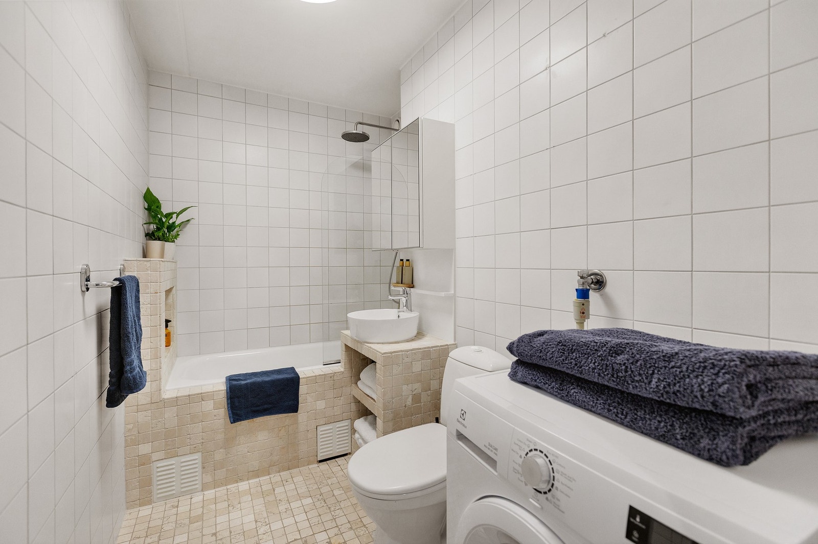 Pent og flislagt bad med elektriske varmekabler og opplegg for vaskemaskin. Galleribilde