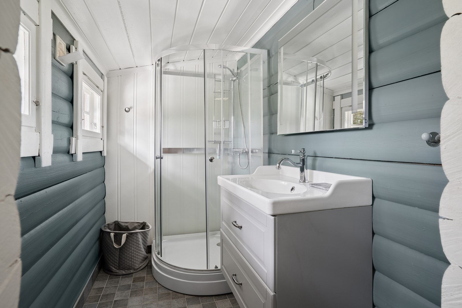 Badet har flislagt gulv med elektriske varmekabler. Innredet med nedfelt servant og dusjkabinett Galleribilde