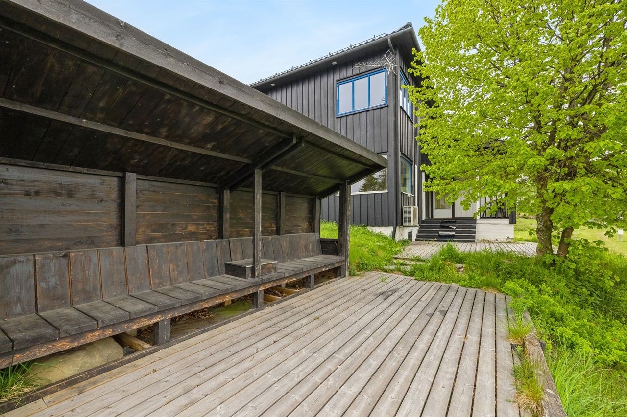 Ytterste del av terrassen har en plassbygd benk med overbygg- en deilig solvegg! Her er det også åpen plass foran for hagebord eller flere sittemøbler. Galleribilde