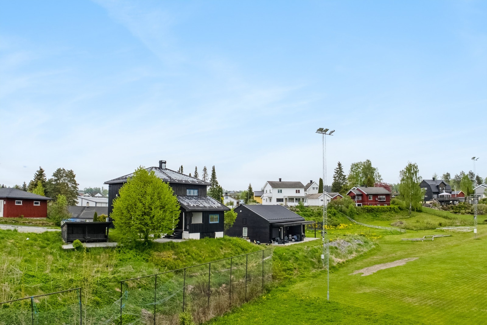 Tomten er inngjerdet og pent opparbeidet med gressplener, prydvekster og gruset gårdsplass. Galleribilde